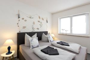 2 Betten in einem weißen Zimmer mit Fenster in der Unterkunft Bungalow Seestern - b47691 in Malchow