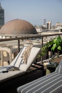 a towel is sitting on a chair on a balcony at Mr. Rothschild by TLV2GO in Tel Aviv +39 photos