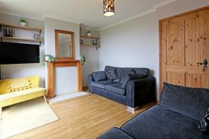 a living room with a couch and a tv at Lovely 3 bedroom house with free parking & garden in Norwich