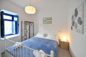 una camera da letto con un letto con un piumone blu e una finestra di Bexis Residences Hydra a Hydra