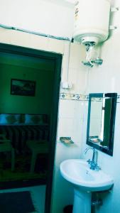 een badkamer met een wastafel en een spiegel bij Vamoose AR Resort in Chamoli
