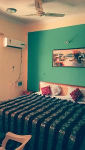 een slaapkamer met een bed met een blauwe muur bij Vamoose AR Resort in Chamoli