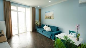 ein Wohnzimmer mit einem blauen Sofa und einem Tisch in der Unterkunft Gent's Inn in Durrës