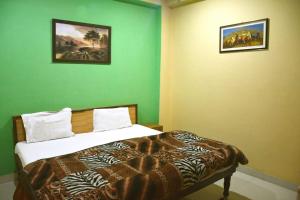 een slaapkamer met een bed in een groene muur bij Vamoose AR Resort in Chamoli