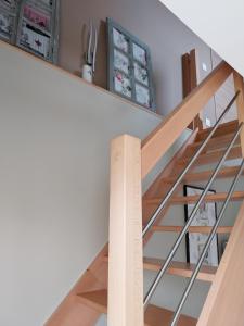 uma escadaria numa casa com piso de madeira e vidro em Gite Du Palefrenier em Brécey