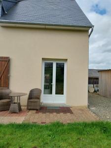 Cette maison dispose d'une terrasse avec une table et des chaises. dans l'établissement Gite Du Palefrenier, à Brécey