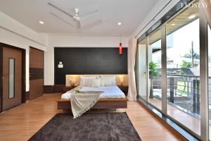 1 dormitorio con 1 cama grande y balcón en EKOSTAY Gold - Amara Villa en Alibaug