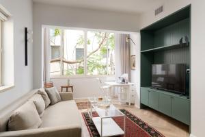 sala de estar con sofá y TV en Exquisite Home on Rothschild Bld by FeelHome, en Tel Aviv