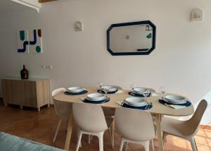 a dining room table with chairs and a mirror at Porto Covo / Costa Alentejana in Porto Covo
