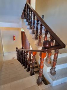 una scala con ringhiere in legno in una casa di King Palace Hotel a Dar es Salaam