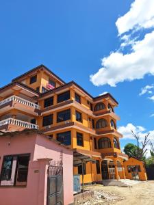 un edificio giallo con un cielo blu sullo sfondo di King Palace Hotel a Dar es Salaam