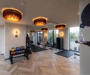einen Fitnessraum mit mehreren Lampen und Trainingsgeräten in einem Zimmer in der Unterkunft The Brondesbury by Nestor in London