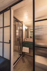 a bathroom with a shower and a sink and a mirror at The Brondesbury by Nestor in London