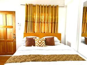 a bedroom with a large white bed with brown pillows at Penthouse Unit with Ocean View at Sonia's Island Stay in Virac