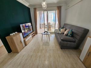un soggiorno con divano e TV di Apartamento Benimar Beach a Benidorm
