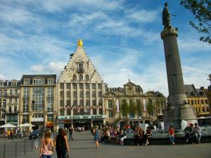 a group of people standing around a fountain in front of a building at Private Room & Spa avec jacuzzi privatif in Lille