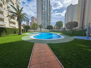 una piscina in mezzo a un parco con edifici di Apartamento Benimar Beach a Benidorm