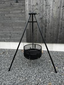 a black swing basket sitting on the ground at Familievennlig Apartament in Tvedestrand