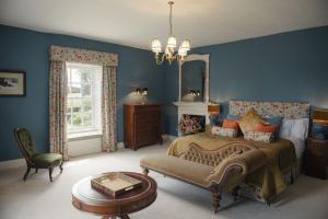 a bedroom with blue walls and a bed and a chair at Shortflatt Tower in Longwitton