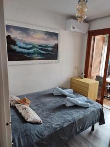 a bedroom with a bed and a painting on the wall at CASA PALANGRE 50 in Torrevieja