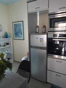 een keuken met een koelkast en een fornuis top oven bij Nelly's Private Resindence in Chania