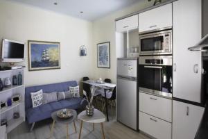 een woonkamer met een blauwe bank en een keuken bij Nelly's Private Resindence in Chania