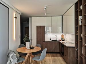 a kitchen with a table and chairs and a kitchen with a sink at New Apartment Wroclaw Parking Place & Self Check in 24H Apartament TARAS Miedziana in Wrocław +22 photos