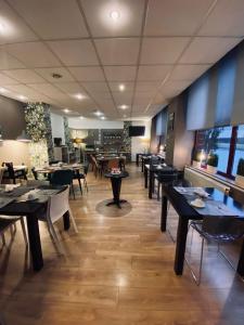 a restaurant with tables and chairs in a room at Hotel Le Pelican in Charleville-Mézières