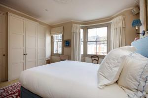 a bedroom with a large white bed and a window at Veeve - Riverside Serenade in London
