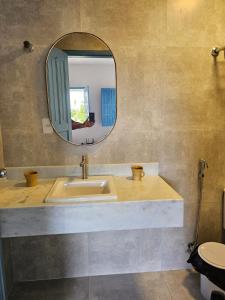 y baño con lavabo y espejo. en Mansão 6/4 Piscina & Mar en Olivença