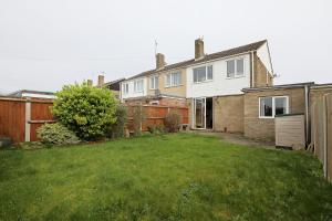 a house with a grass yard in front of it at Lovely 3 bedroom house with free parking & garden in Norwich