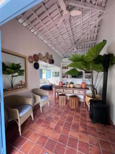 sala de estar con mesa, sillas y plantas en Mansão 6/4 Piscina & Mar en Olivença