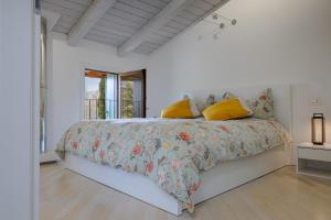 1 dormitorio con 1 cama con edredón de flores y almohadas amarillas en Incantevole vista dalle mura del castello., en Gradisca d'Isonzo