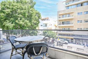 d'une table et de chaises sur un balcon avec vue sur la ville. dans l'établissement Beauty Paramount by HolyGuest, à Tel Aviv