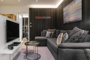 Sala de estar con sofá gris y TV en Baltic House Muschel, en Timmendorfer Strand