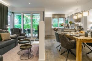 Una cocina y una sala de estar con mesa y sillas. en Baltic House Muschel, en Timmendorfer Strand