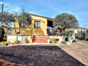 une maison jaune avec une allée en briques dans l'établissement -Villa Gardenia- [Private Garden & Free Parking], à Sarzana