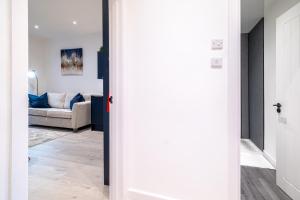 a hallway with a living room with a couch at Holburn Hideaway - SJA Stays - Luxury 2 Bed Apartment in Aberdeen