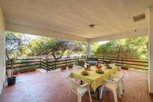 una sala da pranzo con tavolo e sedie sul balcone di Villa Mauro su mare a Calasetta