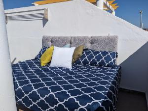 ein blau-weißes Bett mit zwei Kissen darauf in der Unterkunft Sunny days apartment in Playas de Vera + 35 Fotos