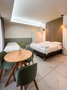 a room with two beds and a table and chairs at La residenza del viale in Treviglio