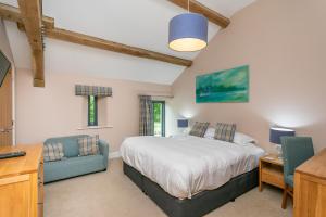 a bedroom with a bed and a desk and a tv at Brockram Barn in Kirkby Stephen