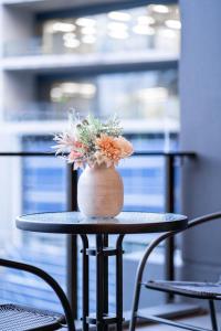 a vase with flowers sitting on a table at Urban Elegance 2B2B w parking, pool South Brisbane in Brisbane