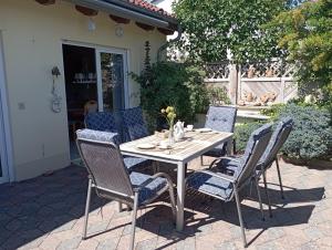 einen Holztisch und Stühle auf einer Terrasse in der Unterkunft Bungalow Seestern - b47691 in Malchow