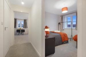 Northfleet的住宿－Gravesend 2 Bed Apartment-2 minutes walk from shops, Restaurants and Motorway. Sleep upto 5，一间卧室配有一张床,另一间卧室配有桌子