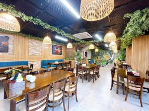 a restaurant with wooden tables and chairs and plants at Mai An Homestays in Móng Cái