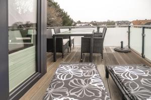 eine Terrasse mit einem Tisch und Stühlen auf dem Balkon in der Unterkunft Baltic House Penthousewohnung Seestern in Timmendorfer Strand