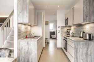 a kitchen with white cabinets and stainless steel appliances at Baltic House Penthousewohnung Seestern in Timmendorfer Strand