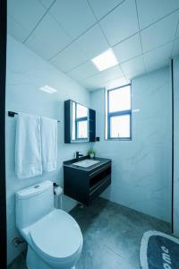 een witte badkamer met een toilet en een wastafel bij Abantu Parkview 2BR Suite near JKIA SGR with Pool Gym Eatery in Nairobi