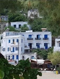 een groot wit gebouw met blauwe ramen op een heuvel bij Lydia Mare in Agios Kirykos